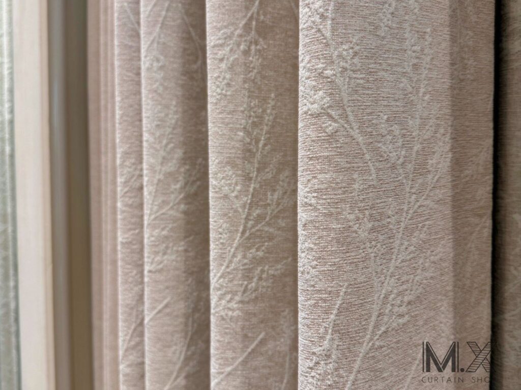 LOGO案例照 (3) - 沐馨窗簾 整體為淡米杏色基底,融入自然系枝葉圖樣,花紋以同色系稍淺的色線織出,呈現低調優雅的素雅風格。圖案靜謐細膩,彷彿樹影輕拂,為空間增添一抹自然柔和的氛圍。