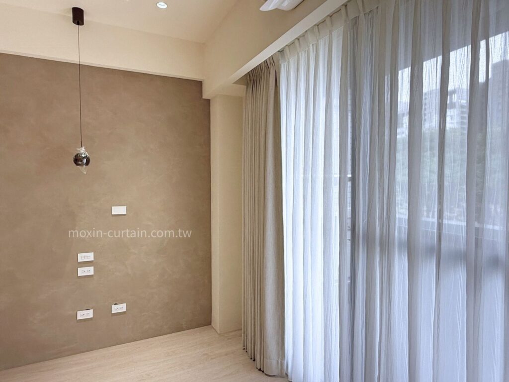 丁安琪LOGO案例照 (4) - 沐馨窗簾 沐馨窗簾從側面角度拍攝 客廳空間 灰色牆面搭配 縐褶感蛇形紗簾 微光映入