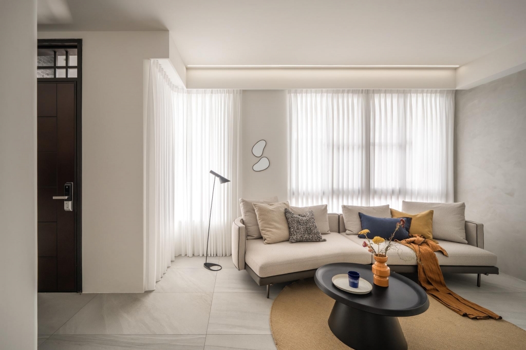 沐馨窗簾  客廳空間利用可彎曲軌道，製作 L 型窗簾延伸，純白透光紗簾柔化光線，同時保有隱私。