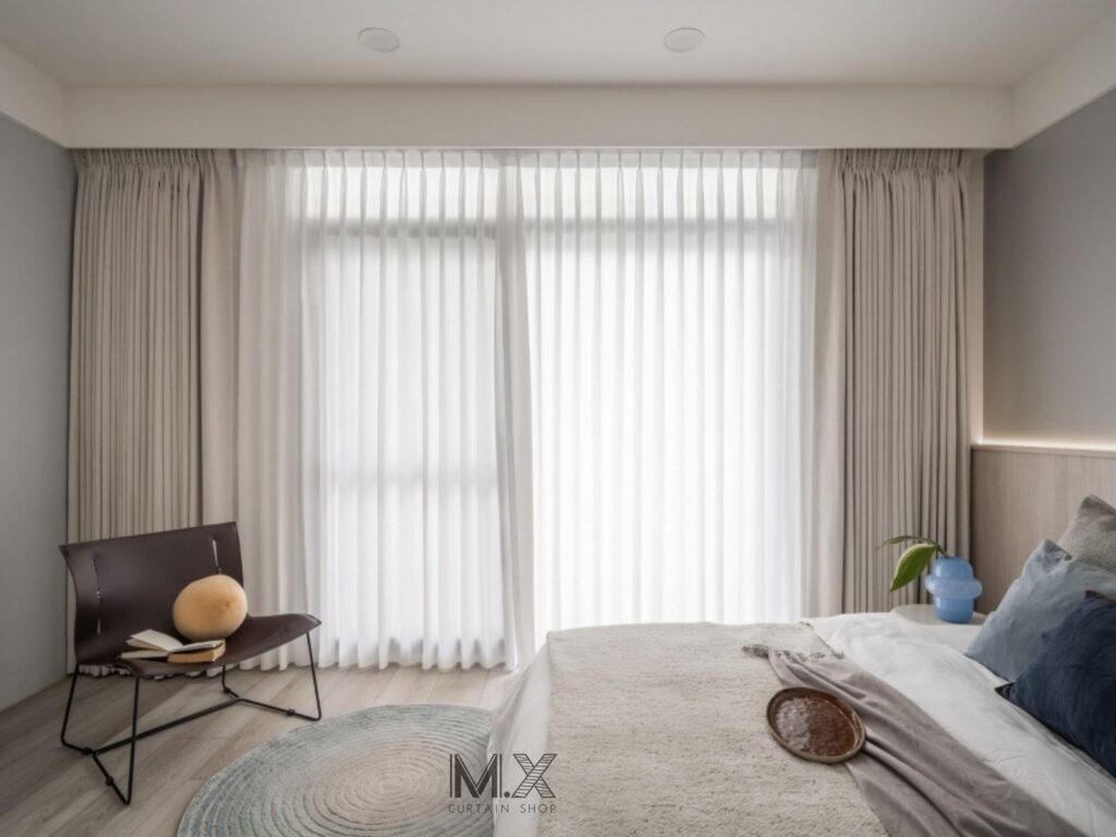 沐馨窗簾臥室空間 布簾選用米白色系，呼應木質床頭板與灰藍寢具，整體更顯飯店式氛圍。