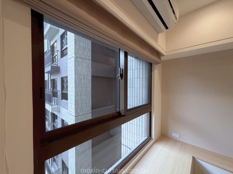 Room corner with a large brown-framed window and a wall-mounted air conditioner; outside view shows a neighboring building with balconies and tiled walls.